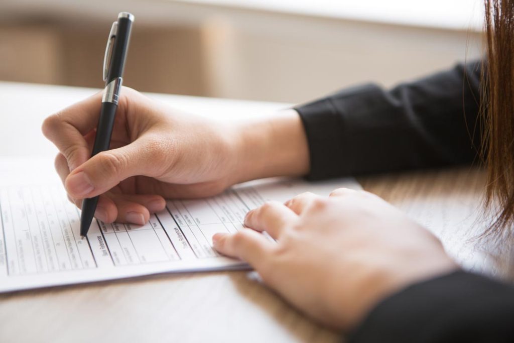 cropped view woman filling application form